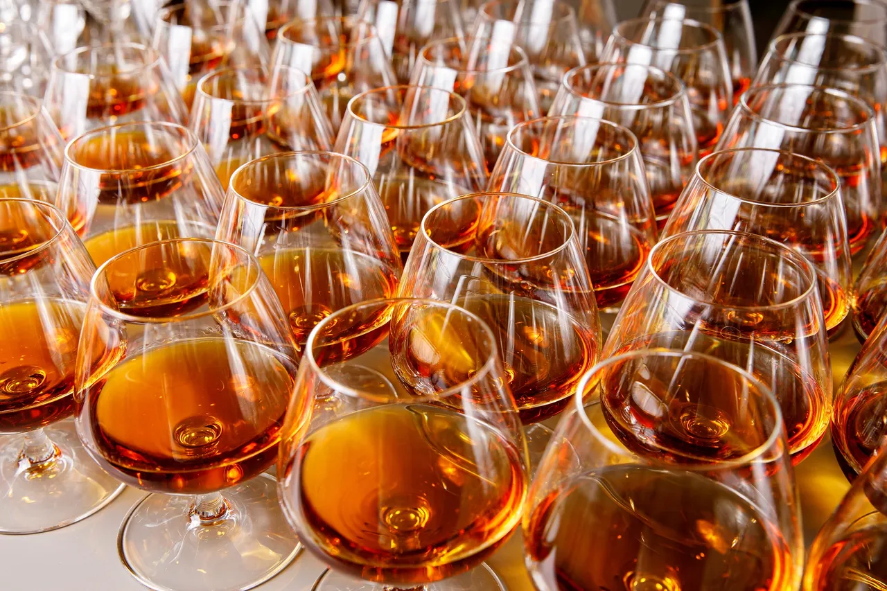 Rows of filled wine glasses closely arranged.